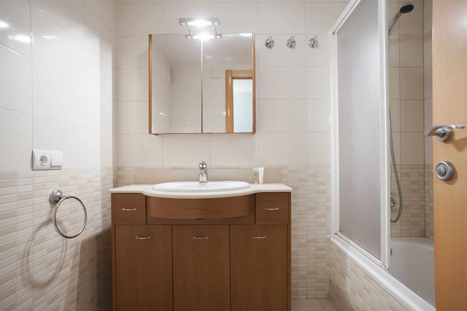 Badkamer met douche en bad